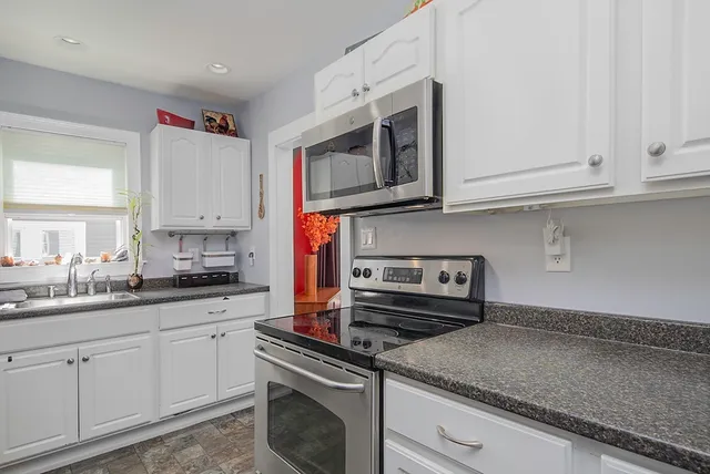 a kitchen with stainless steel appliances granite countertop a sink and a stove