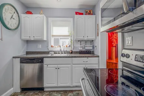 a kitchen with stainless steel appliances granite countertop a white stove top oven and sink