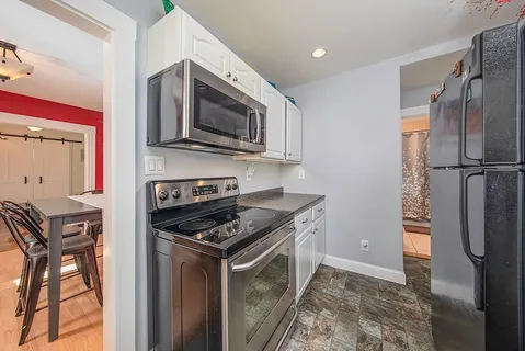 a kitchen with stainless steel appliances granite countertop a refrigerator stove and microwave