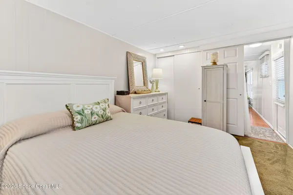 a bedroom with a large bed and a wooden floor