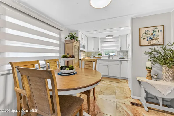 a kitchen with stainless steel appliances kitchen island granite countertop a table and chairs in it