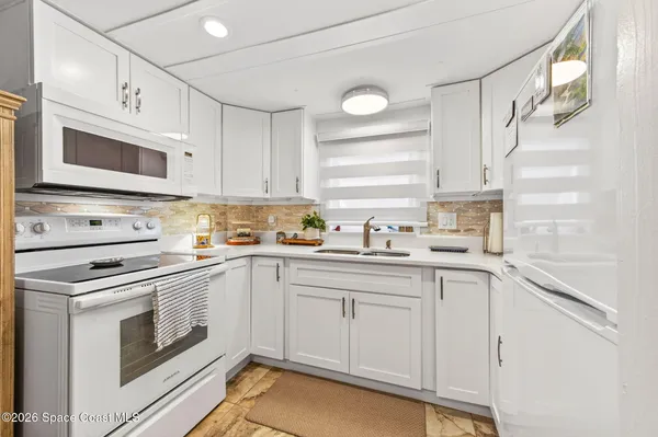 a kitchen with cabinets appliances a sink and a window