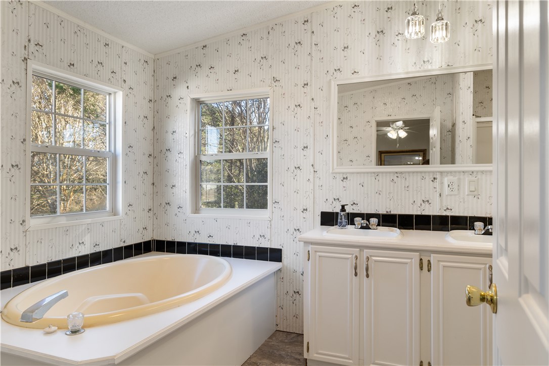811 Pine Grove Road Seneca, SC 29678 - Photo 9 of 20 This bathroom features a soaking tub, dual vanities, and bright windows.