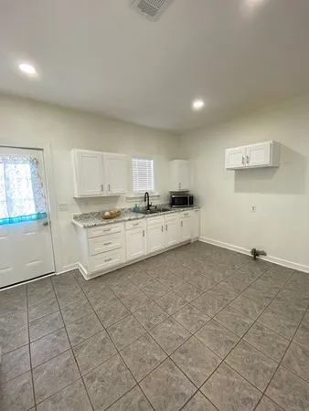 a kitchen with granite countertop a stove a sink and a refrigerator