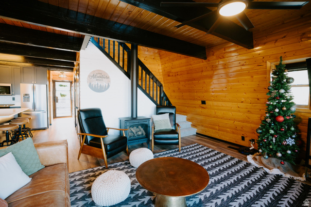 1413 Basel Drive Midway, UT 84049 - Photo 27 of 137 Living area with wood walls, a wood stove, wood finished floors, a wooden ceiling with exposed beams, and ceiling fan