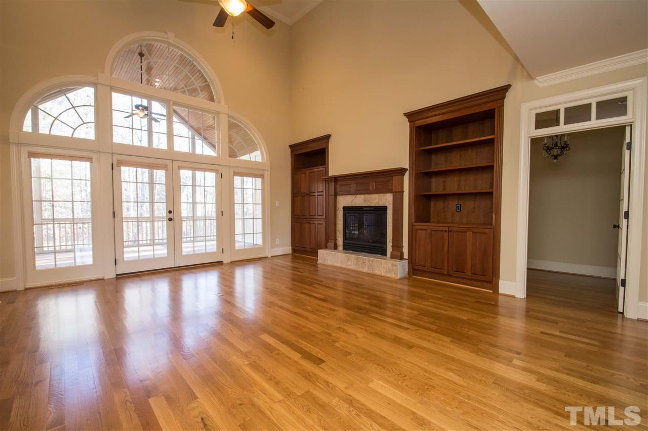 1068 Tacketts Pond Drive Raleigh, NC 27614 - Photo 6 of 25 Amazing two story family room with an amazing gas log fireplace and gorgeous built-ins. Enjoy all the space and wall of architectural windows with access to the screened porch Family Room
