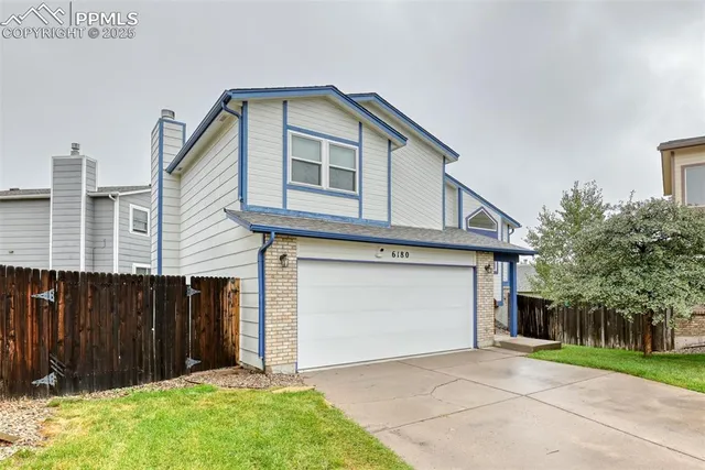 a front view of a house with a garden and garage