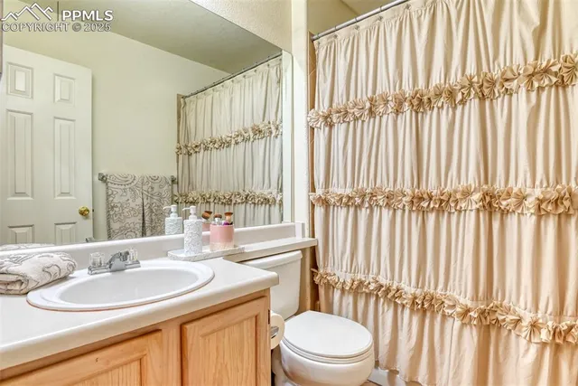 a bathroom with a double vanity sink toilet and a tub