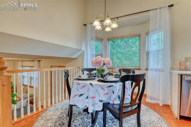 a dining room with furniture a large window and a chandelier