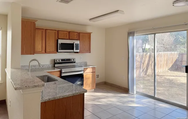 a kitchen with stainless steel appliances granite countertop a stove a sink and a refrigerator