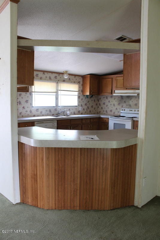 15577 Flounder Road Jacksonville, FL 32226 - Photo 20 of 35 a kitchen with a sink a window and cabinets
