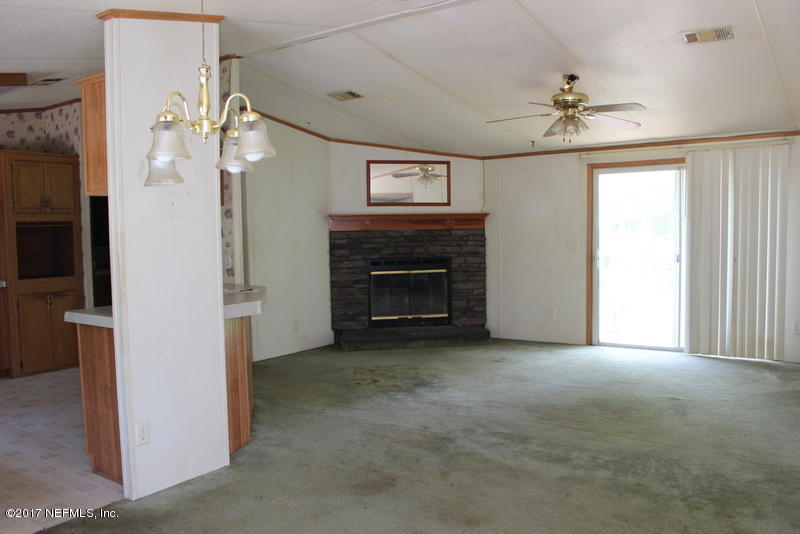 15577 Flounder Road Jacksonville, FL 32226 - Photo 25 of 35 a view of an empty room with chandelier fan and fire place