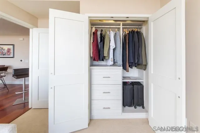 a view of walk in closet with clothes and shoes