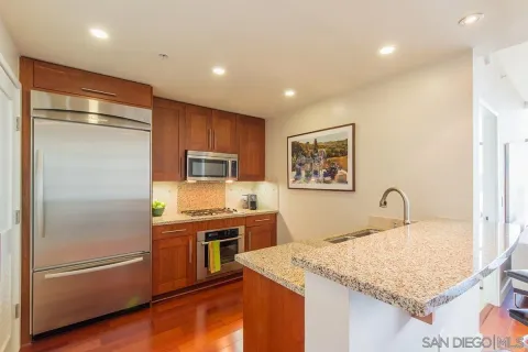 a kitchen with stainless steel appliances granite countertop a refrigerator and a stove top oven