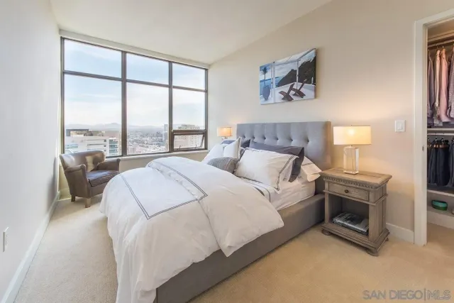 a bedroom with a bed and a large window