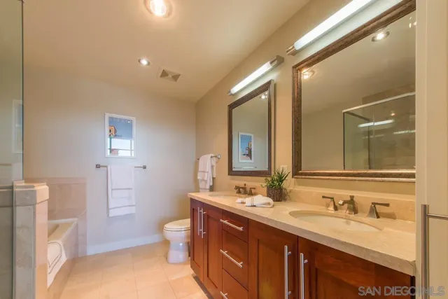 a spacious bathroom with a granite countertop sink mirror and a toilet