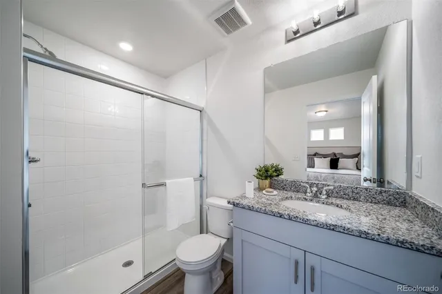 a bathroom with a granite countertop sink toilet and shower