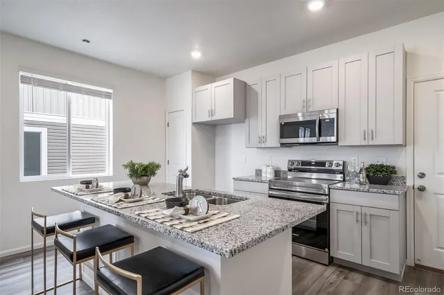 a kitchen with stainless steel appliances kitchen island granite countertop a sink and cabinets