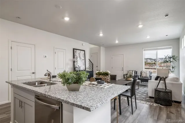 a kitchen with granite countertop a table and chairs in it