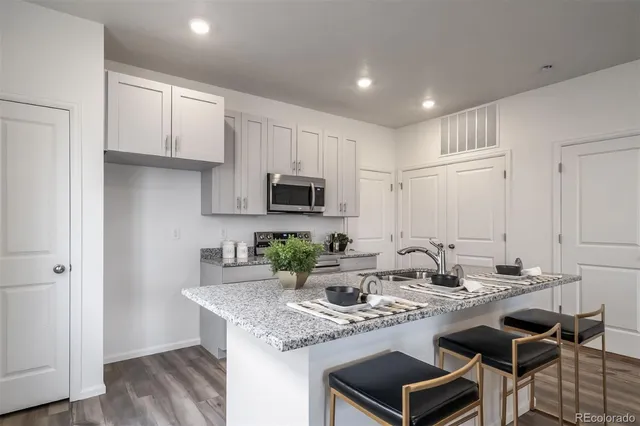 a kitchen with stainless steel appliances granite countertop a sink stove and cabinets