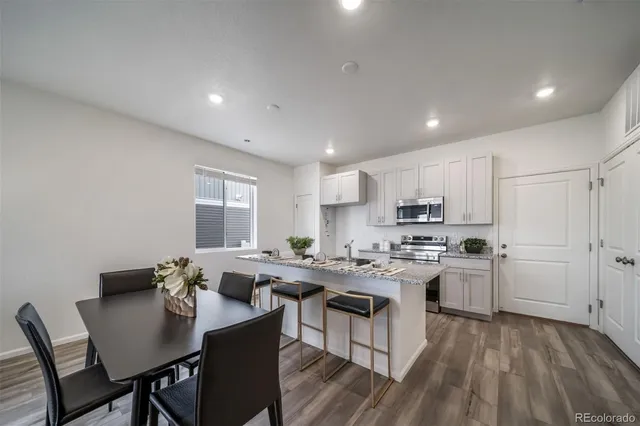 a kitchen with a table chairs stove and cabinets