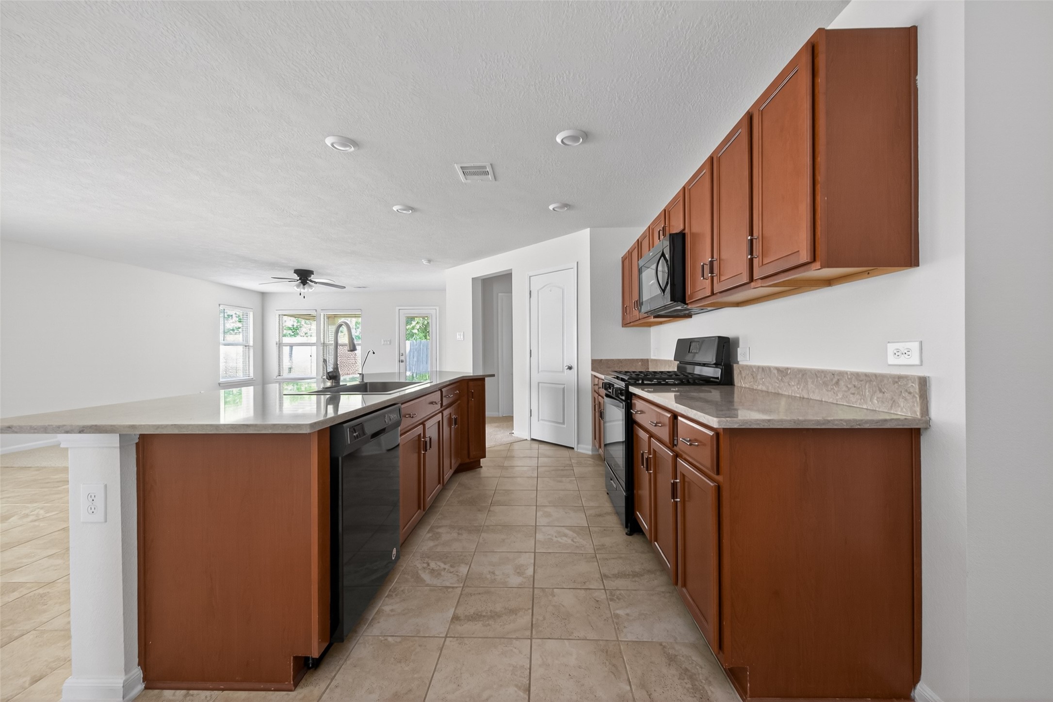 2754 Cayden Creek Way Conroe, TX 77304 - Photo 16 of 40 a large kitchen with stainless steel appliances granite countertop a stove a sink and a refrigerator