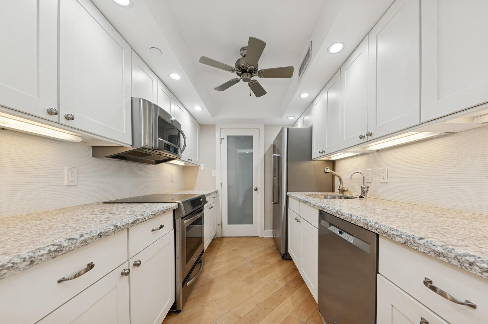 3000 North Ocean Drive, Unit 18G Singer Island, FL 33404 - Photo 5 of 46 a kitchen with stainless steel appliances granite countertop a sink a stove and cabinets