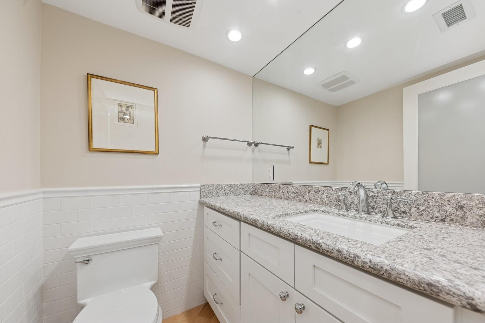 3000 North Ocean Drive, Unit 18G Singer Island, FL 33404 - Photo 8 of 46 a bathroom with a granite countertop sink mirror vanity and toilet