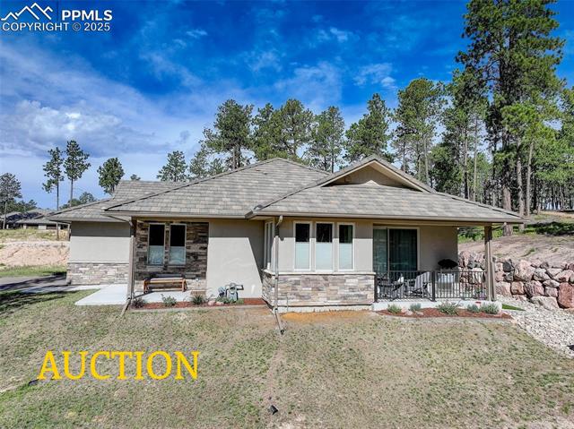 3144 Promise Point Colorado Springs, CO 80921 - Photo 1 of 1 View of front of property featuring stucco siding, a front lawn, stone siding, and a porch