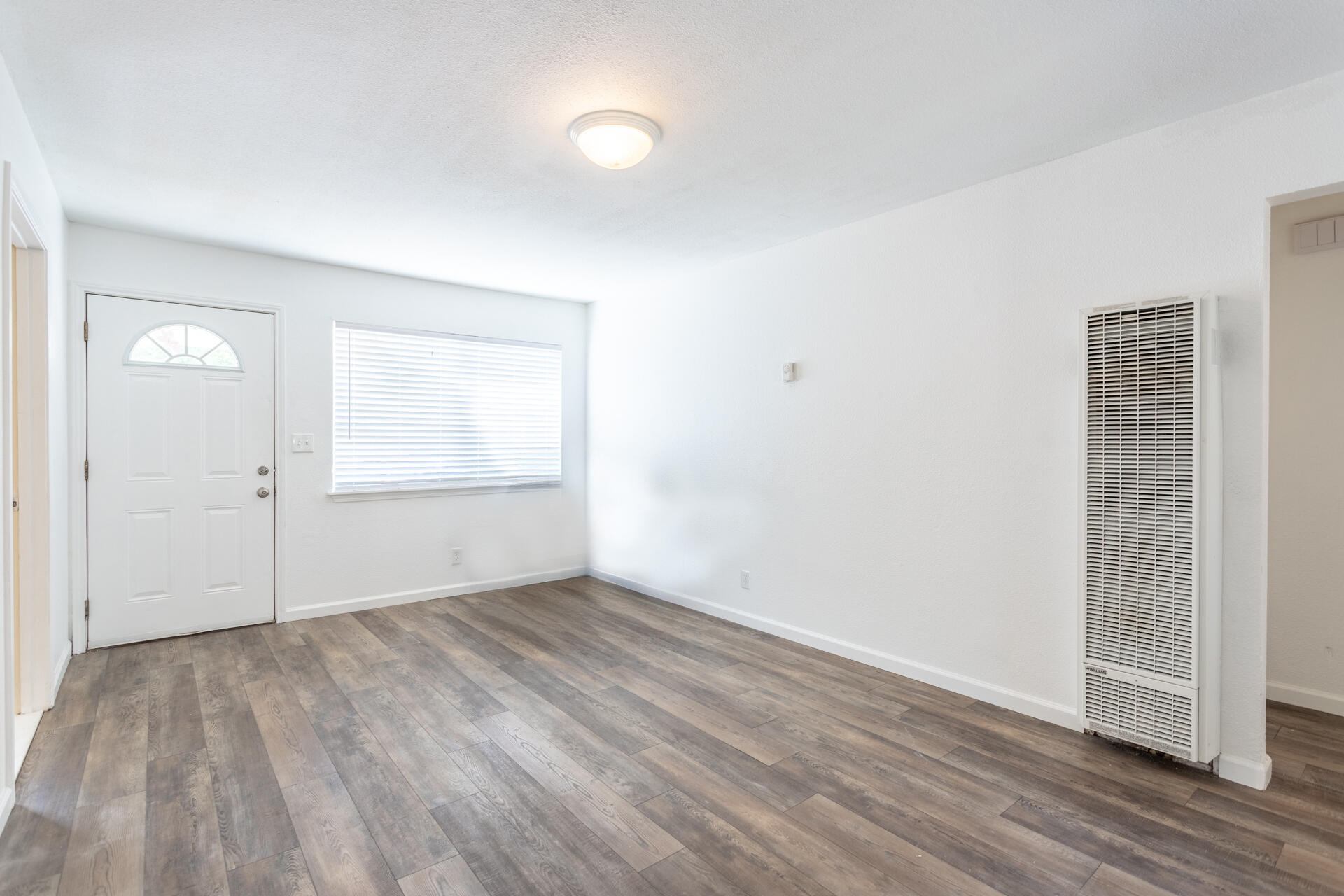 3252 Daisy Street Anderson, CA 96007 - Photo 4 of 20 an empty room with wooden floor and windows