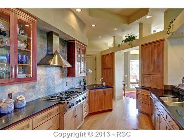 4265 Hidden Rock Road Colorado Springs, CO 80908 - Photo 10 of 25 Gourmet Kitchen w/ Black Granite Counter Tops, Slate Backsplash, 2 Sinks, Stainless Steel Appliances, Cherry Cabinets, Walk-in Pantry & Counter Bar