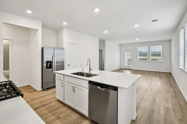a kitchen with a sink stove and refrigerator