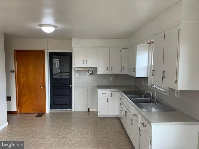 a kitchen with granite countertop a sink and a refrigerator