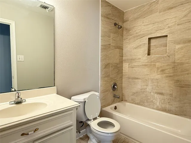 a bathroom with a granite countertop toilet a sink and bathtub
