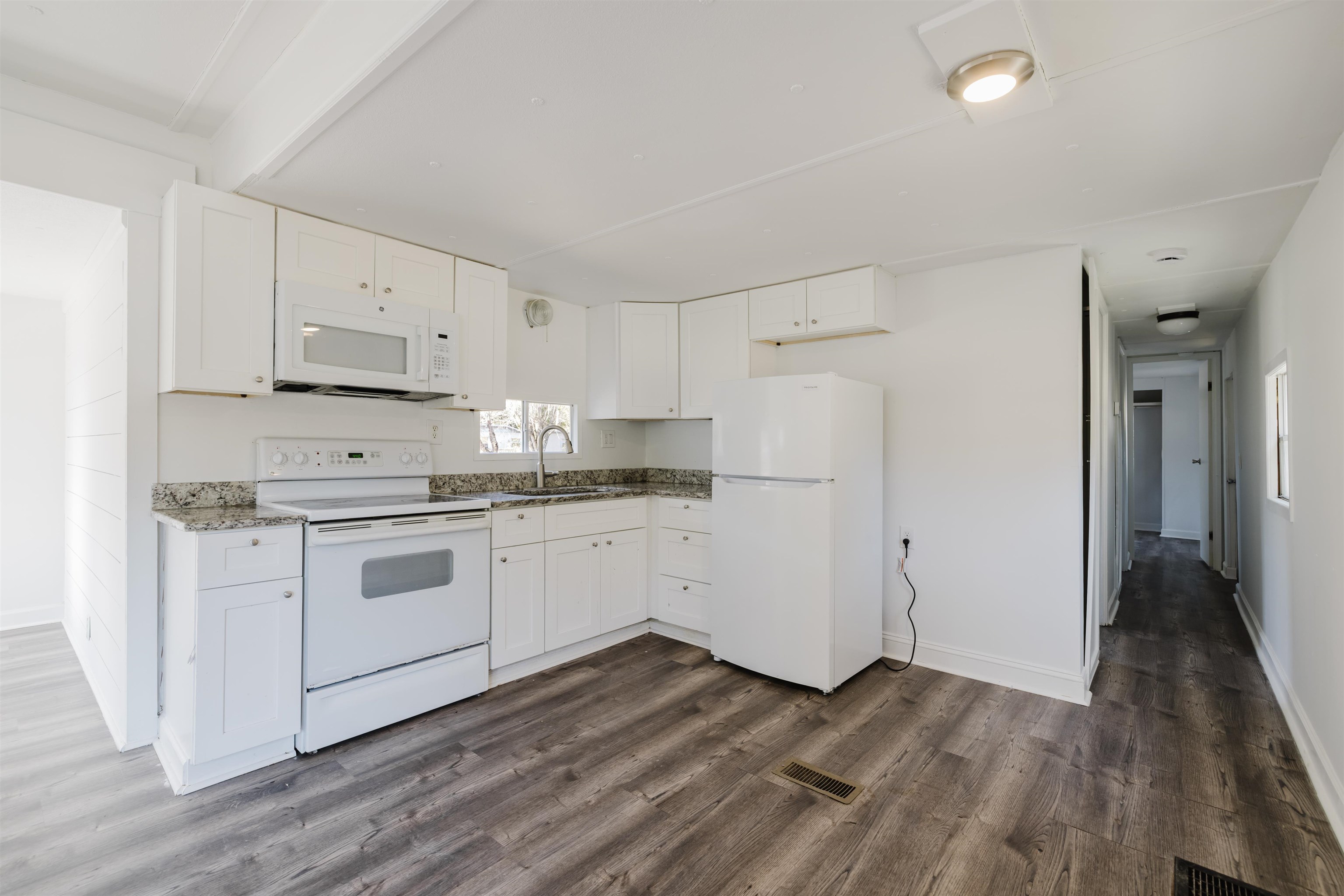 1805 Cactus Drive Loris, SC 29569 - Photo 2 of 31 Kitchen featuring white appliances, white cabinetry, dark wood-type flooring, and dark stone countertops