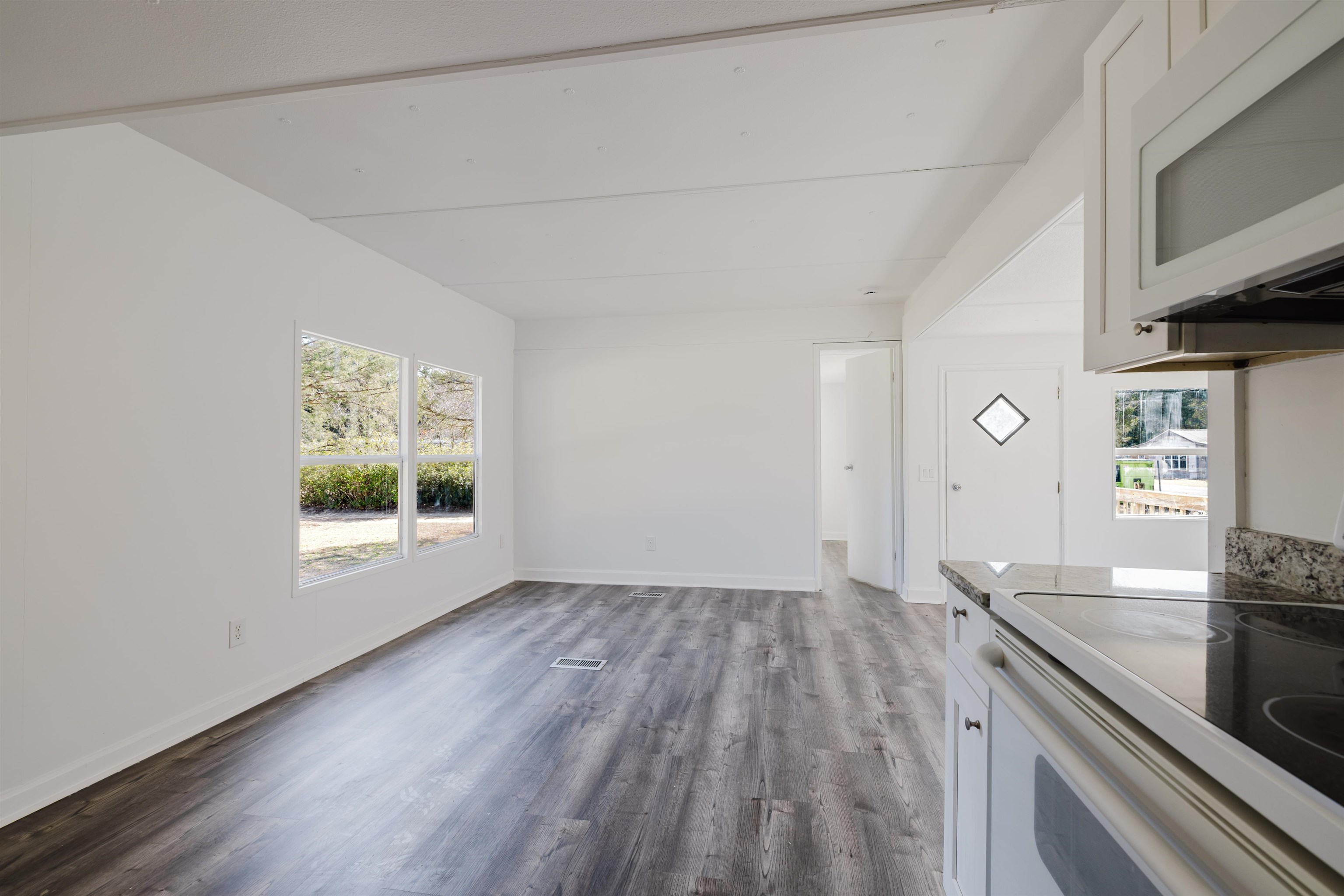 1805 Cactus Drive Loris, SC 29569 - Photo 30 of 31 Kitchen with white microwave, dark wood-style floors, range with electric stovetop, and healthy amount of natural light