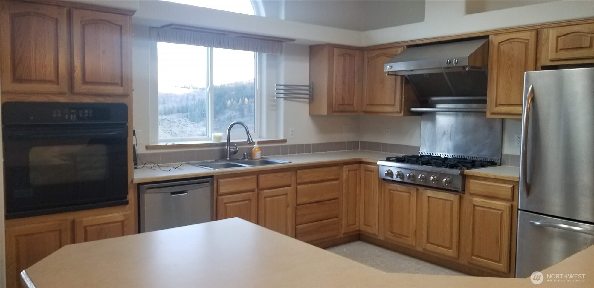 1579 Pine Creek Road, Unit A Tonasket, WA 98855 - Photo 18 of 24 a kitchen with stainless steel appliances granite countertop a sink stove and refrigerator