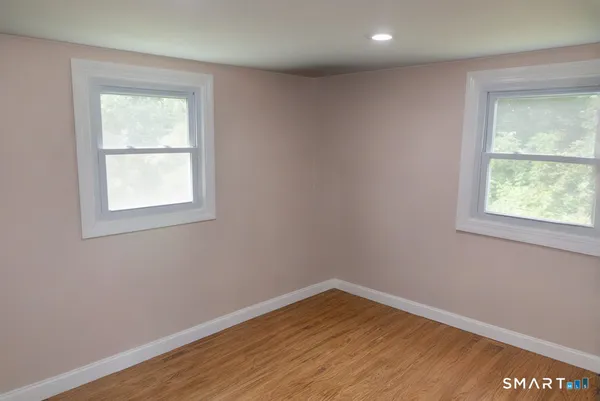 an empty room with wooden floor and a window