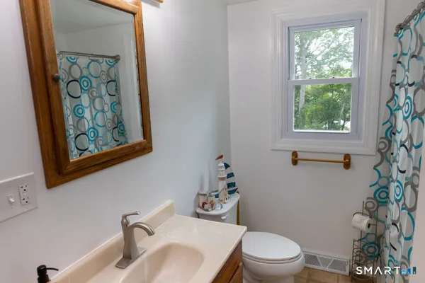 a bathroom with a toilet a sink and a window
