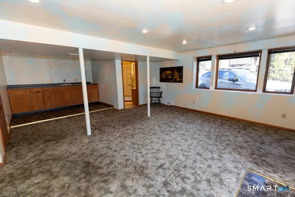 a view of an empty room with window and stairs