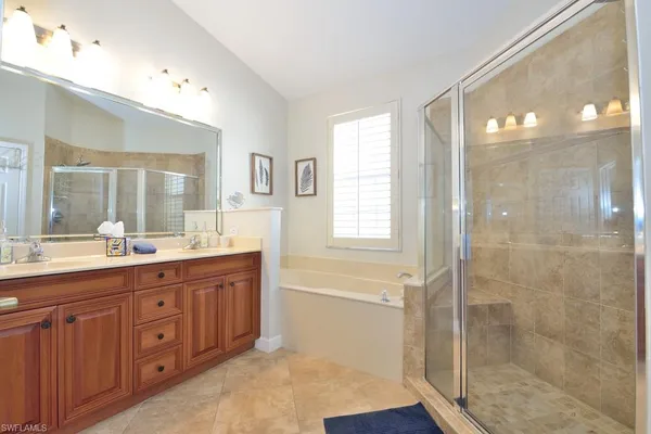 a spacious bathroom with a granite countertop sink a mirror a shower and a bathtub