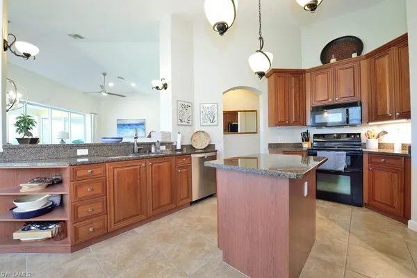 a kitchen with stainless steel appliances granite countertop a sink a stove and a refrigerator