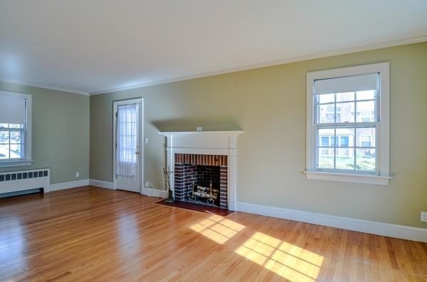 77 West Central Street Natick, MA 01760 - Photo 12 of 22 an empty room with windows a fireplace and wooden floor