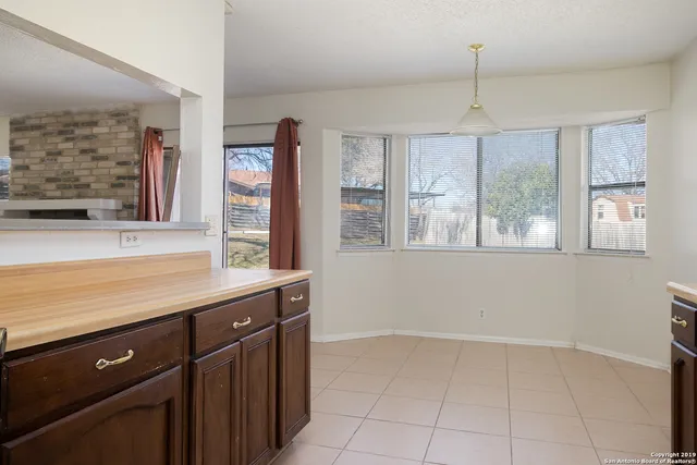 a view of a kitchen with wooden floor and windows