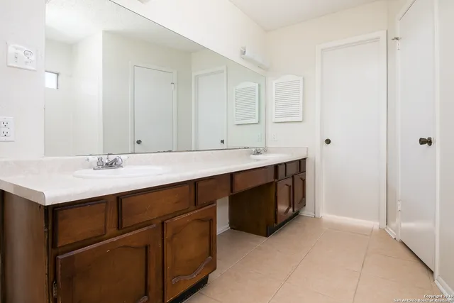 a spacious bathroom with a sink and a mirror