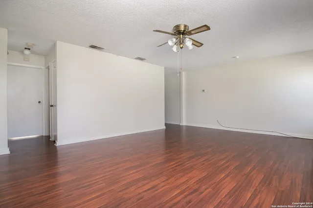 a view of an empty room with wooden floor