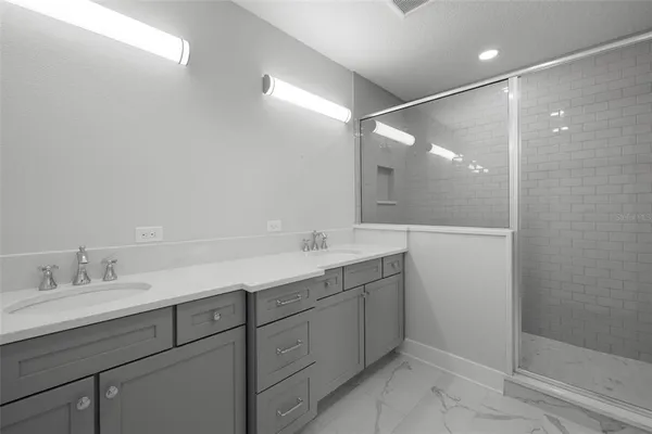 a bathroom with a double vanity sink mirror and shower