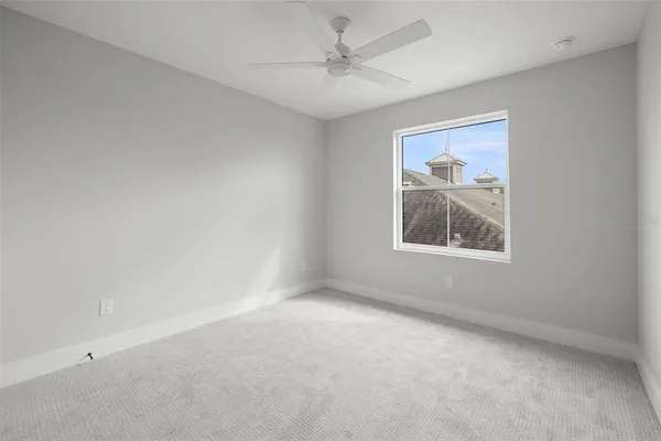an empty room with windows and fan