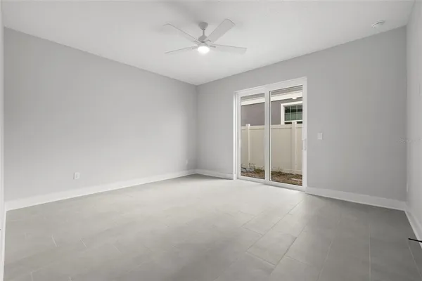 an empty room with a ceiling fan and a window