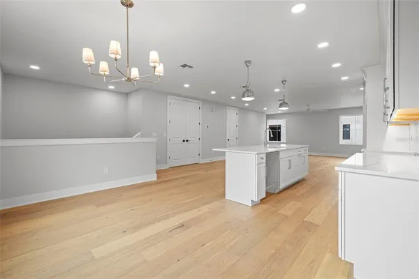 a view of a kitchen with kitchen island a sink stainless steel appliances and cabinets